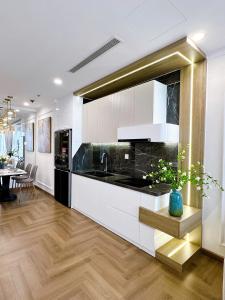 a kitchen with black and white counters and a table at Luxury Apartment in Vinhomes Times City - KaBi Home in Hanoi +25 photos