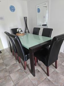 mesa de comedor con sillas negras y mesa verde en Coorong Lakeside Cottage, en Meningie