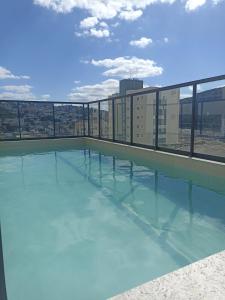 a swimming pool on the roof of a building at Charmoso, moderno e central! 11 in Poços de Caldas