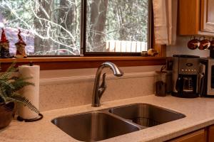 a kitchen counter with a sink and a window at Chase's River Cabin - Hot-tub Firepit & Fireplace in Granite Falls +31 photos