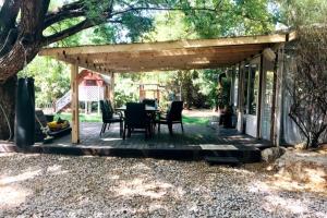 a pergola with a table and chairs on a deck at Levis in Chorazim