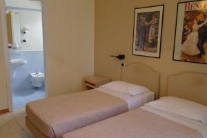 a hotel room with two beds and a bathroom at Hotel Armando' s in Sulmona