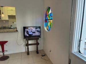 a tv on a table in a room with a mirror at Apartamento p 10 com 3 quartos e 2 banheiros in Porto Alegre