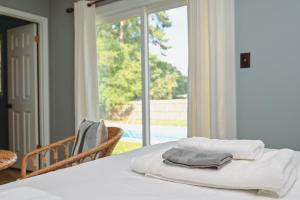 a pile of towels sitting on a table in front of a window at Master Vacation-Private pool Boutique Design House in Augusta +21 photos