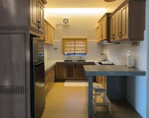 a kitchen with wooden cabinets and a blue counter top at Banglo Inap Asiah in Kuala Terengganu