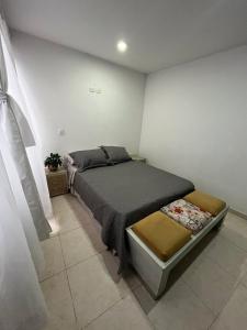 Un dormitorio con una cama y una silla dentro. en Excellent studio apartment!, en Ibagué