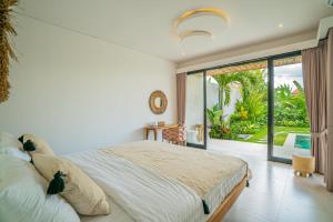 een slaapkamer met een groot bed en een groot raam bij Sun Garden Villa - 2BR Villa in Kerobokan in Kerobokan +97 foto's