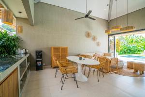 een keuken en eetkamer met een tafel en stoelen bij Sun Garden Villa - 2BR Villa in Kerobokan in Kerobokan