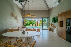 een woonkamer met een witte tafel en stoelen bij Sun Garden Villa - 2BR Villa in Kerobokan in Kerobokan