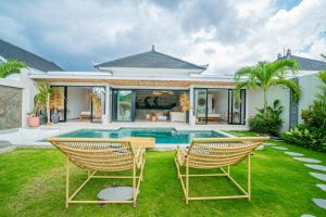 een achtertuin met 2 stoelen en een zwembad bij Sun Garden Villa - 2BR Villa in Kerobokan in Kerobokan