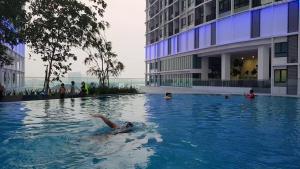 a person laying in a swimming pool in a building at JZ ISoHo i-City Studio 2 beds in Shah Alam