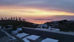 un balcone con sedie e vista sul tramonto. di Villa Secret 55 Mykonos a Fanari