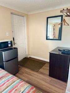 a room with a bed and a desk and a mirror at Gratiot View Motel in Saginaw