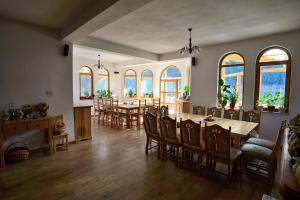 a dining room with a table and chairs and windows at Pensiunea Casa Elvira in Vama