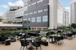a patio with tables and chairs in front of a building at Quincy House Singapore in Singapore