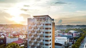 沙马林达FOX Lite Hotel Samarinda的一座高大的建筑,以城市为背景