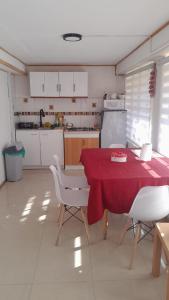 a kitchen with a table with a red table cloth at Hostal Flor Austral in Chile Chico