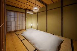 Postel nebo postele na pokoji v ubytování Yoshimigura Machiya House