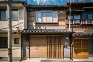 a house with two garage doors and a balcony at Tokikaze Machiya House in Kanazawa