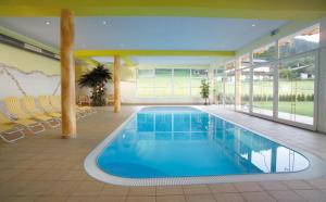 ein großer Pool in einem Haus mit einem Schwimmpoolvisor in der Unterkunft Activ Wellness - Appartement Schermerhof in Westendorf