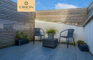 two chairs sitting on a patio with plants at The Kepties 3 - Luxurious Serviced Apartment by ORION SHORT STAYS in Arbroath
