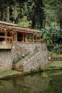 un edificio con una pared de piedra junto a un cuerpo de agua en Cattaleya Eco, en Yumbo