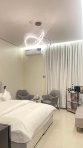 ハーイルにあるاستوديو أنيق مع جلسة جانبية وركن للقهوةのベッドと天井扇風機のある寝室