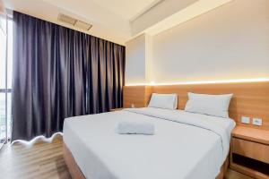 Кровать или кровати в номере Gorgeous 1BR Apartment at The Smith Alam Sutera By Travelio +8 фотографий