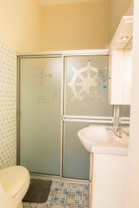a bathroom with a shower with a toilet and a sink at Casa Moderna in Acajutla