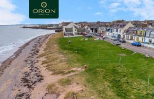 an aerial view of a beach with houses and the ocean at Creel Cottage No 3, Beach Front, Arbroath in Arbroath +40 photos