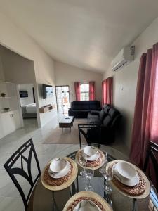 a dining room with two tables and a living room at OceanView Oasis in Discovery Bay