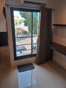 een kamer met een raam met uitzicht op een patio bij Minty house in Hua Hin