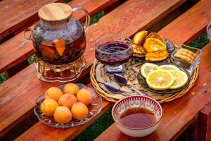a table with bowls of fruit and a jug of tea at Bosogo Resort in Pervomayskoye