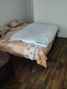 a bed in a room with a wooden floor at Mount view guest house in Jammu