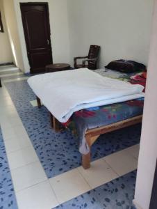 a bed with a white sheet on top of it at Mount view guest house in Jammu