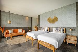 two beds in a hotel room with a couch at Villa Damai Rohani Private Pool Villas with Valley Views Adults Only in Sidemen