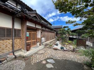 a building with a gate and a stone walkway in front of it at はたご屋ちゅうべ in Taki