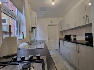 レスターにあるNice Living Serviced Accommodations Leicester 2のシンクとコンロのあるキッチン トップオーブン