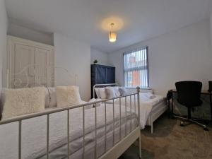 レスターにあるNice Living Serviced Accommodations Leicester 2のベッドと机と窓のある寝室