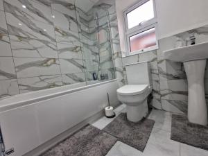 レスターにあるNice Living Serviced Accommodations Leicester 2のトイレ、浴槽、洗面台を備えたバスルーム