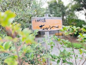 a sign with asian writing on it in a garden at はたご屋ちゅうべ in Taki