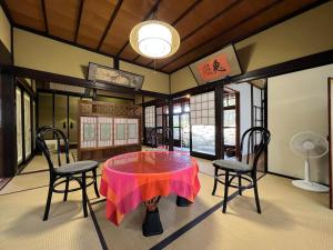 a room with a table with a pink table cloth on it at はたご屋ちゅうべ in Taki
