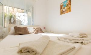 Un dormitorio blanco con una cama con toallas. en Dubrovnik center apartment, en Dubrovnik
