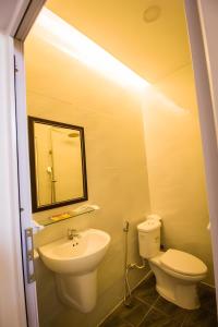 a bathroom with a sink and a toilet and a mirror at 1991 Hotel in Phan Thiet