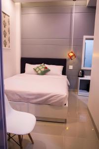 a small bedroom with a bed and a chair at 1991 Hotel in Phan Thiet