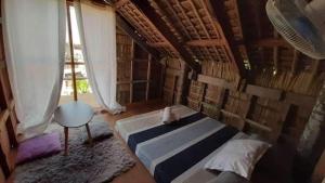 a bedroom with a bed in a room with books at A-Frame Cottage 2, Puraran Surf Resort in Baras