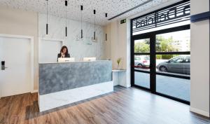 a woman standing at a counter in an office at Sercotel Córdoba Delicias in Córdoba