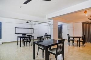 a dining room with black tables and chairs at Townhouse De Alphabet Hotel in Hyderabad