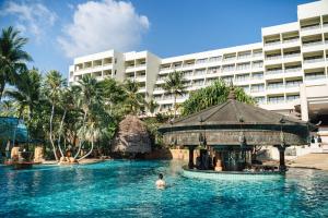 a person in a pool in front of a hotel at Paradox Resort Phuket in Karon Beach