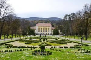 a garden with a large building in the background at Apartment Katarina in Banja Koviljača